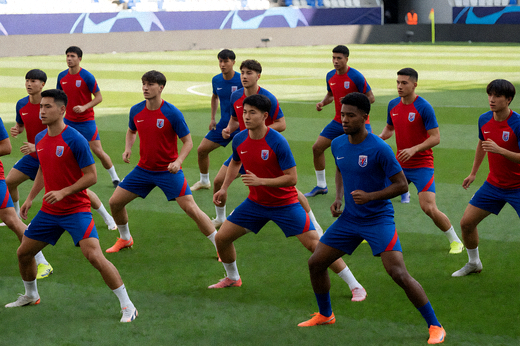 欧冠赛前球队在球场上进行热身训练的场景
